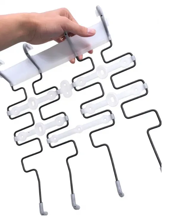 Finished seat back spring assembly held by hand, showing white PP sections around black formed wire